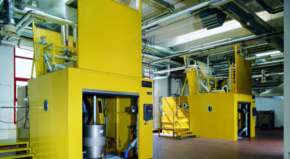 gelbe Maschinen in der Produktionshalle der Adler Lackfabrik