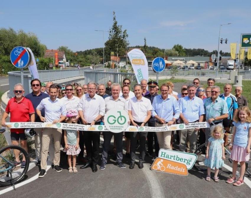 Eine große Menschengruppe hinter einem Absperrband, seitlich Fahrräder