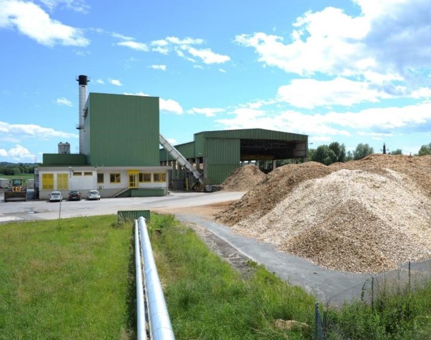 Aufgetürmte Holzspäne vor einem Heizkraftwerk